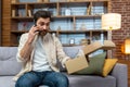 Angry cheated man at home with phone and boxed parcel received, arguing on phone talking to online store customer Royalty Free Stock Photo