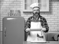 Angry chef bakers man raising rolling pin threateningly in white kitchen. Royalty Free Stock Photo