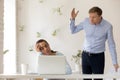 Angry confused boss catching sleeping employee at workplace