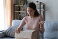 Angry confused woman unpacking parcel, wrong or broken order