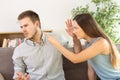 Angry couple arguing on a sofa at home