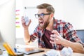 Angry crazy designer yelling and crumpling paper on his workplace Royalty Free Stock Photo