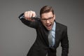 Angry criminal businessman with gun on grey background.