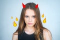 Angry cute devil. Fashion portrait of a beautiful young woman posing over white background. Close up portrait of a
