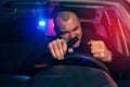 Angry drunk man sitting in car with beer bottle