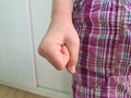 Angry emotional clenched fist of child near leg Royalty Free Stock Photo