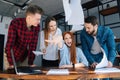 Angry exhausted young business woman under stress throwing documents sitting at desk looking at camera, multiracial Royalty Free Stock Photo