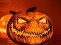 The angry face with the sharp teeth of the orange scary pumpkin