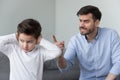 Angry father shouting at stubborn fussy little son closing ears Royalty Free Stock Photo