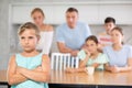 Angry female child turned away from parents and sisters and ignores relatives. Royalty Free Stock Photo