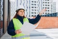 Angry female construction worker in hardhat with folder outdoors. Young woman construction worker in hard hat crazy and Royalty Free Stock Photo