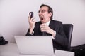 Angry and frustraded business man screaming on a cell phone in the office Royalty Free Stock Photo