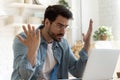 Angry frustrated young man furious about laptop computer malfunction Royalty Free Stock Photo