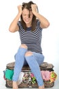 Angry Frustrated Young Woman Sitting on a Suitcase Pulling Her Hair Royalty Free Stock Photo