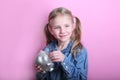 Angry funny young girl with silver piggy bank on pink background. save money concept. Royalty Free Stock Photo