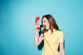 Angry furious girl in dress screaming at retro telephone tube