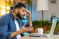 Angry furious Indian man freelancer using laptop working at home office nervous breakdown at work Royalty Free Stock Photo