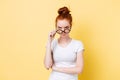 Angry ginger woman looking through eyeglasses at the camera Royalty Free Stock Photo