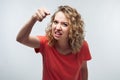 Angry girl with curly hair looking at the camera and pointing her finger at you. Human emotions concept Royalty Free Stock Photo