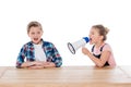 Angry girl with megaphone yelling on her confused brother