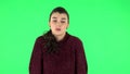 Angry girl is waving her hands in indignation, shrugs. Green screen