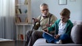 Angry grandpa scolding grandson for playing video game on tablet, generation gap Royalty Free Stock Photo