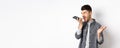 Angry guy shouting at speakerphone, scream on mobile phone, leaving angry voice message, standing against white Royalty Free Stock Photo