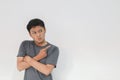 Angry and hate face of young Asian man in gray t-shirt with hand point on empty space Royalty Free Stock Photo