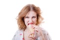 Angry or hungry pretty girl eating ice cream cone looking at camera isolated on white background Royalty Free Stock Photo