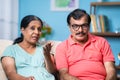 angry Indian senior couple while watching sports match on tv or television due to loss - concept of entertainment Royalty Free Stock Photo