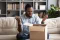 Angry irritated African American man dissatisfied by received parcel