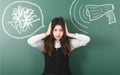 Angry and irritated teenage girl closes her ears from megaphone