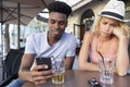 Angry jealous young female as boyfriend uses phone