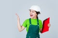 angry kid in hard hat making notes. child hold document folder. Kid learn how to be construction worker builder with Royalty Free Stock Photo