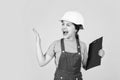 angry kid in hard hat making notes. child hold document folder. Kid learn how to be construction worker builder with Royalty Free Stock Photo