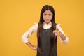 Angry kid in school uniform point accusing finger yellow background, accuse