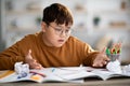 Angry korean teenager looking at exercise book and gesturing Royalty Free Stock Photo