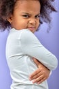 Angry little black girl showing frustration and disagreement, isolated on purple background