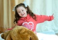 Angry little girl beating her teddy bear - domestic abuse concept. Girl 4-5 year old punishes toy bear