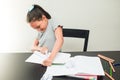 Angry little girl breaking the notebook on the black table. Concept of frustrated schoolgirl doing homework at home Royalty Free Stock Photo