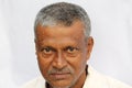 Angry looking senior Indian man face portrait on white background. Royalty Free Stock Photo