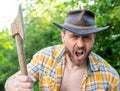 angry lumberjack with axe in selective focus. angry lumberjack with axe outdoor. Royalty Free Stock Photo