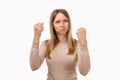 Angry blonde girl raising fists furious at camera. Rage and aggressive concept. Studio shot white background