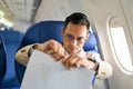 Angry, mad and furious Asian businessman tearing contract during the flight for his business trip Royalty Free Stock Photo