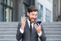 Angry male businessman cry talking on the phone outside business man shouting on call outdoors. Nervous mad professional Royalty Free Stock Photo