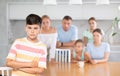 Angry male child turned away from parents and sisters and ignores relatives. Royalty Free Stock Photo