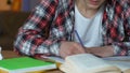 Angry male student throwing notebooks from table, examination stress, impatience