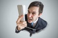 Angry man is calling and shouting to the telephone. View from above Royalty Free Stock Photo