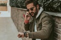 Angry man checking the time while talking on the phone Royalty Free Stock Photo