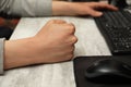 Angry man with clenched fist working on computer at table, closeup Royalty Free Stock Photo